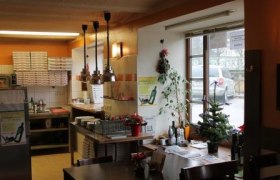 Pizzastube Corrado, © Stadtgemeinde Scheibbs Innenansicht einer Pizzeria mit Tischen, Stühlen und Dekorationen.