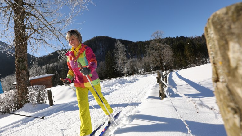 Langlaufen auf der Seeauloipe Lunz, © Tourismusverein Lunz am See Eine Frau beim Langlaufen auf einer verschneiten Loipe mit blauem Himmel im Hintergrund.