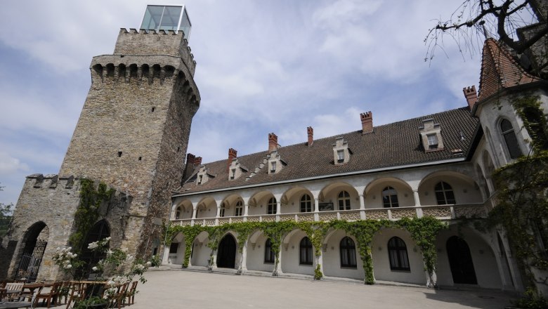 Schlosshof, © Magistrat Waidhofen/Ybbs Ein historischer Schlosshof mit einem steinernen Turm und einem Gebäude mit Arkaden und Kletterpflanzen.