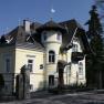 Aussenansicht, © Villa Nova Außenansicht einer gelben Villa mit Türmchen und Balkon.