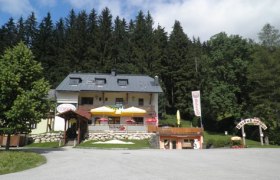 Pizza-Restaurant Fuchswald, © ÖTV Ein Restaurant mit Terrasse und Sonnenschirmen vor einem Wald.