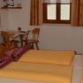 Klein Schöntal, © Klein Schöntal Gemütliches Schlafzimmer mit Doppelbett, Holzmöbeln und kleinem Tisch mit Stühlen.