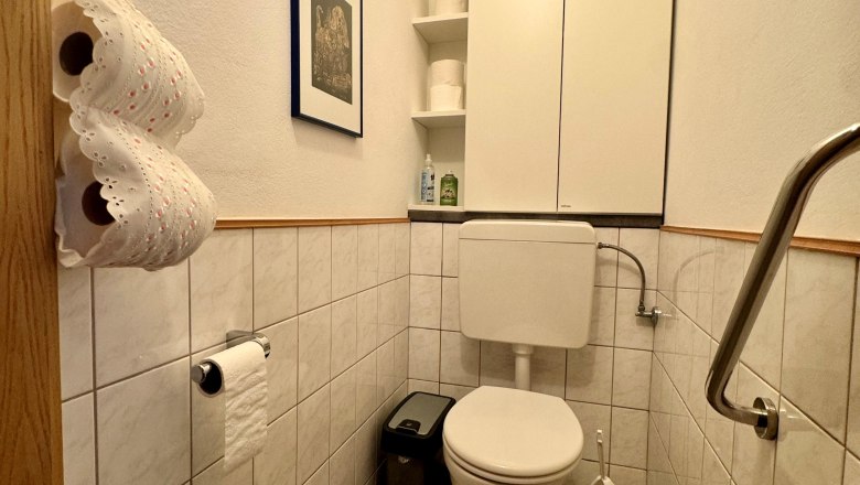 Ferienwohnung Schindlegger, © Familie Schindlegger Kleines Badezimmer mit Toilette, weißen Fliesen und einem Schrank.