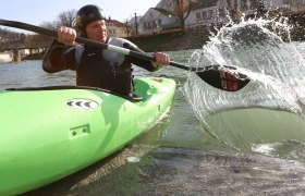 Auf Bootstour auf der Erlauf, © schwarz-koenig.at Person in grünem Kajak paddelt auf einem Fluss.