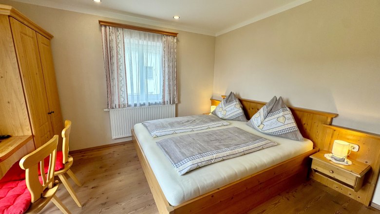 Urlaub am Moaserhof, © Familie Buber Gemütliches Schlafzimmer mit Holzmöbeln, Doppelbett und Schreibtisch.