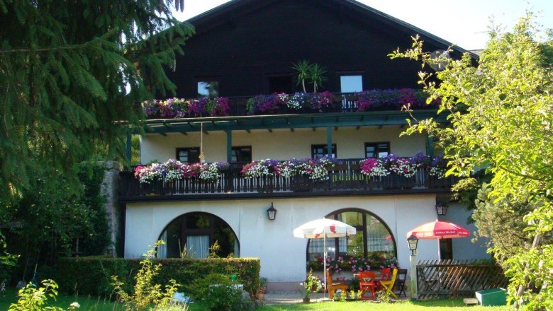 Steinbruchwirt Scheibbs, © privat Ein traditionelles Gasthaus mit Holzbalkon und Blumen in Scheibbs, umgeben von einem grünen Garten.