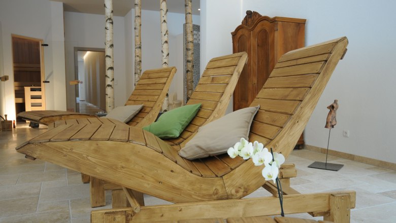 Fastenhaus Maria Seesal, © zVg Fastenhaus Innenansicht eines Wellnessbereichs mit Holzliegen, Kissen und Birkenstämmen.