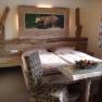 Höhensteinstube Familie Helmel, © Fam. Helmel Rustikales Schlafzimmer mit Holzmöbeln und Bärenbild an der Wand.