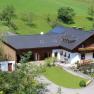 Bauernhof Lueg, © zVg Fam. Fallmann Luftaufnahme eines Bauernhofs mit grünem Dach und Blumendekorationen.
