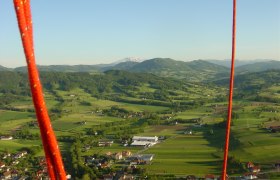 Mit dem Ballon übers Mostviertel fliegen, © Mostviertel Ballooning, Andreas Simoner Landschaft im Mostviertel aus einem Heißluftballon mit roten Seilen im Vordergrund.