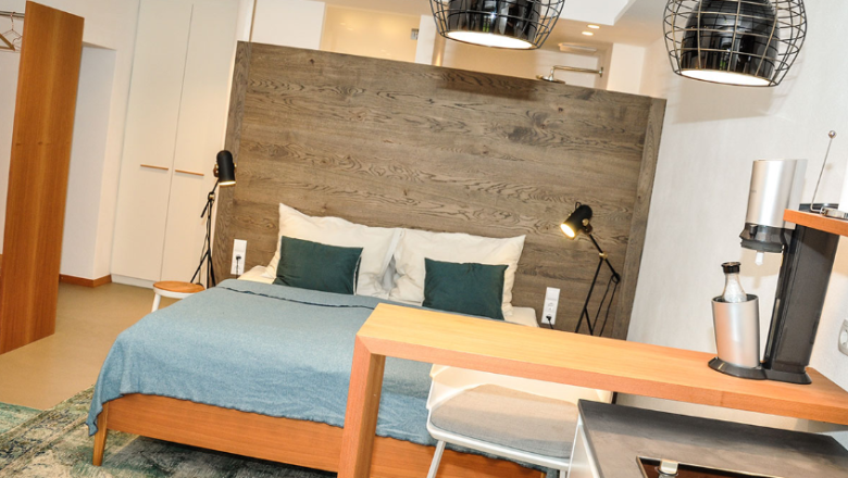 Modernes Studio-Apartment mit Bett, K&uuml;che und stilvoller Beleuchtung.