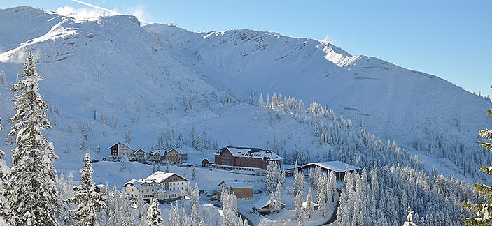 Winterlandschaft mit verschneiten Bergen und Geb&auml;uden am Hochkar.