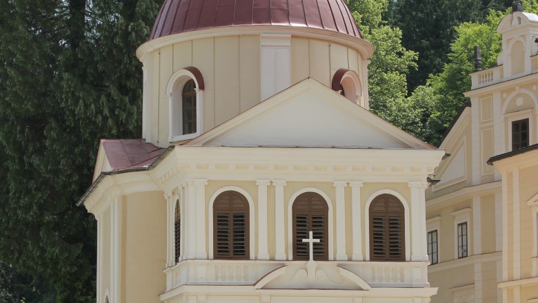 Die T&ouml;pperkapelle in Neubruck mit ihrer markanten Kuppel und klassizistischen Architektur, umgeben von B&auml;umen.