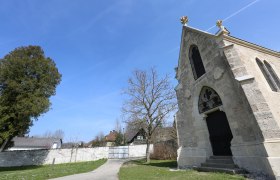 T&ouml;ppermausoleum mit blauem Himmel und B&auml;umen im Hintergrund.
