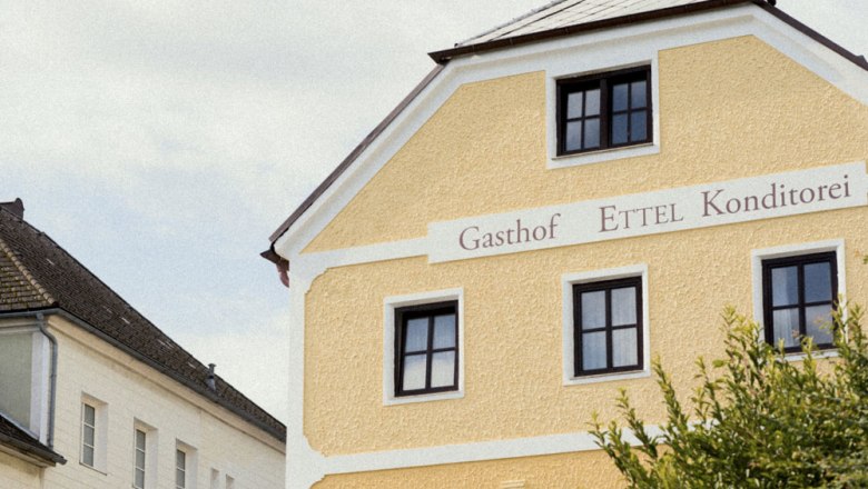 Gelbes Geb&auml;ude mit der Aufschrift 'Gasthof Ettel Konditorei'.