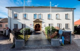 Historisches Gebäude mit weißer Fassade und mehreren Fenstern, bekannt als Hofrichterhaus.