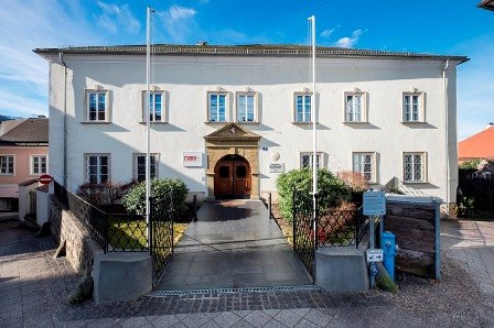 Historisches Gebäude mit weißer Fassade und mehreren Fenstern, bekannt als Hofrichterhaus.