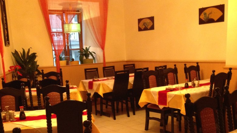 Innenansicht eines asiatischen Restaurants mit gedeckten Tischen und St&uuml;hlen.