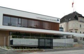 Modernes Geb&auml;ude des Landesklinikums mit Glasfassade und &auml;lterem Anbau.