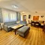 Wohnzimmer einer Ferienwohnung mit blauem Sofa und einer zus&auml;tzlichen Eckbank mit Tisch