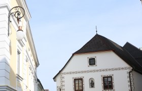 Historische Straßenlaterne an einem Gebäude in einer Altstadt.
