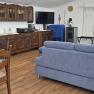 Wohnzimmer einer Ferienwohnung mit blauer Couch, Holzm&ouml;beln und Esstisch.