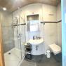 Modernes Badezimmer mit Dusche, Waschbecken und Toilette.