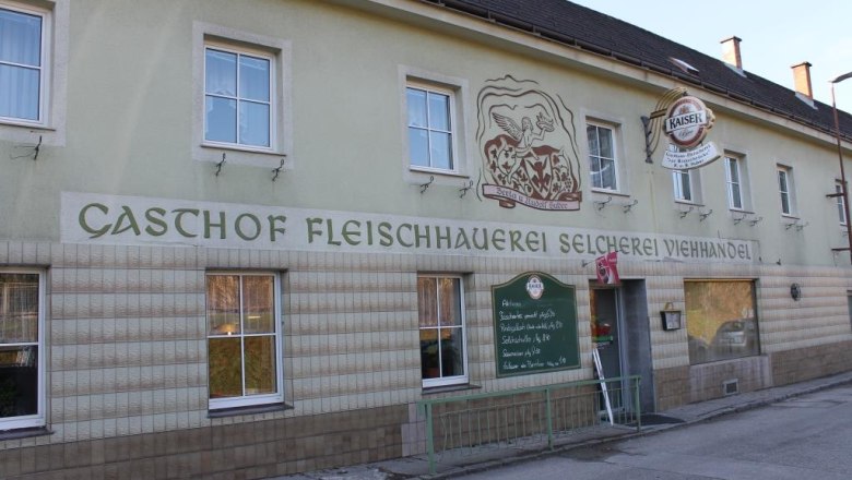Außenansicht eines Gasthofs mit der Aufschrift 'Gasthof Fleischhauerei Selcherei Viehhandel'.
